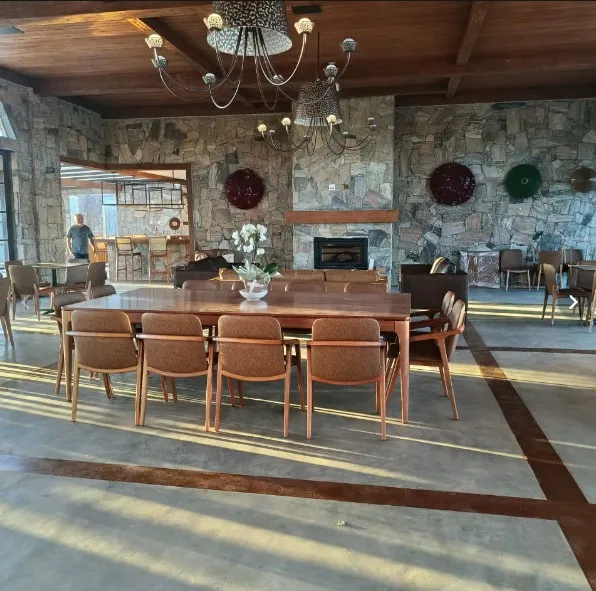 Mesa longa de madeira no salão de pedra da Casa Vinnus
