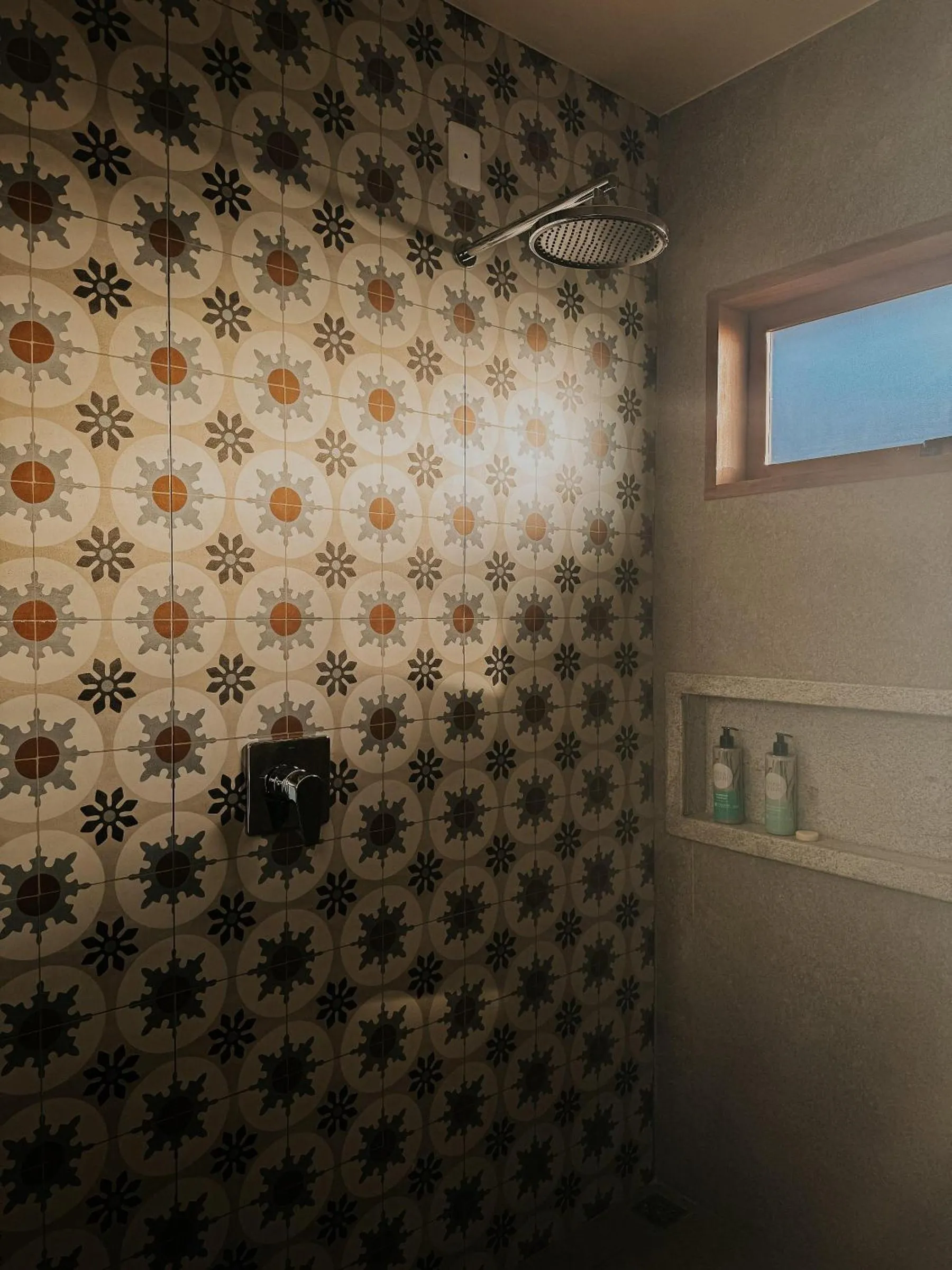Banheiro da cabana com azulejos estampados e ducha