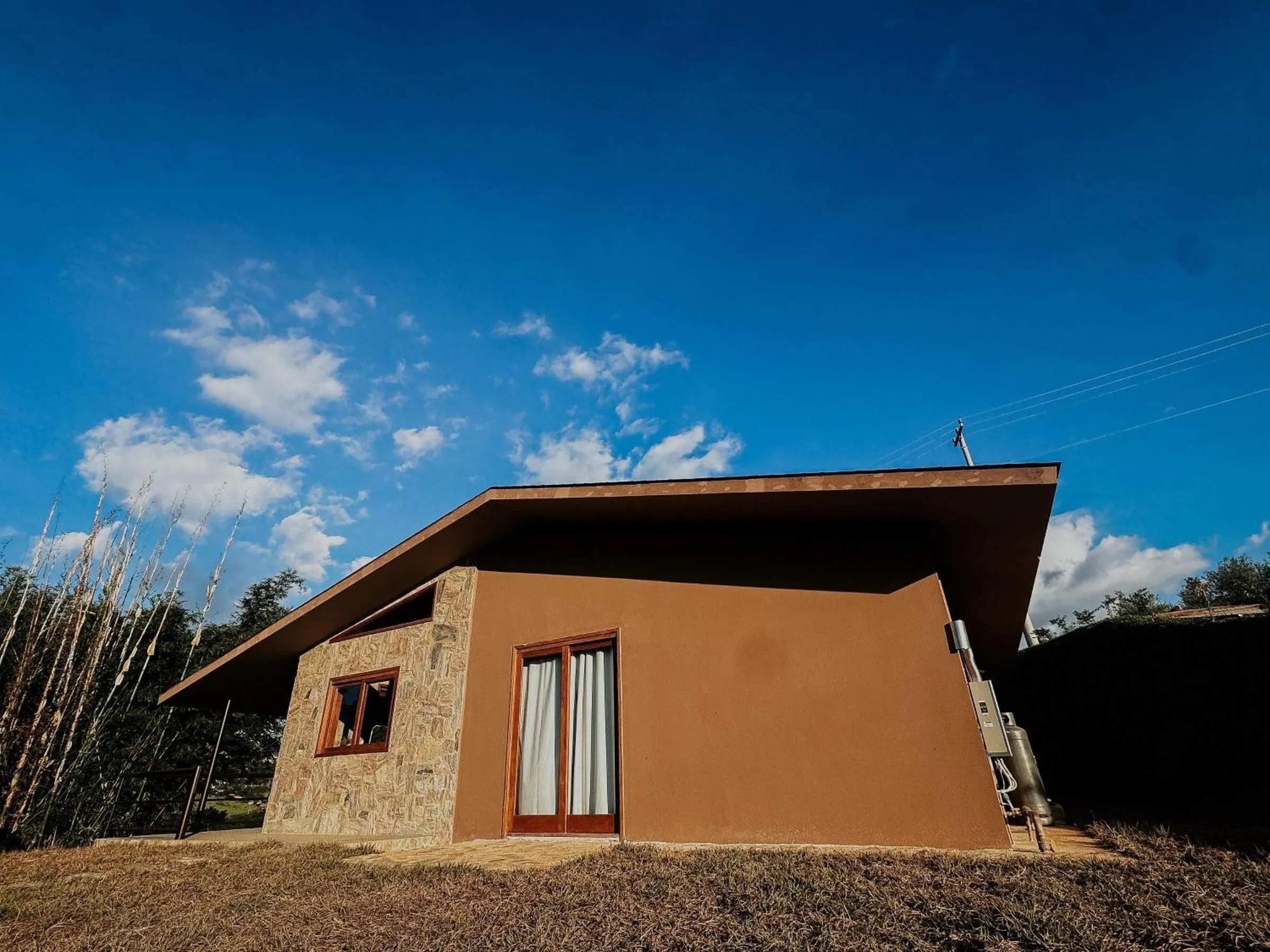 Cabana de pedra da Villa Arouca sob o céu azul da serra