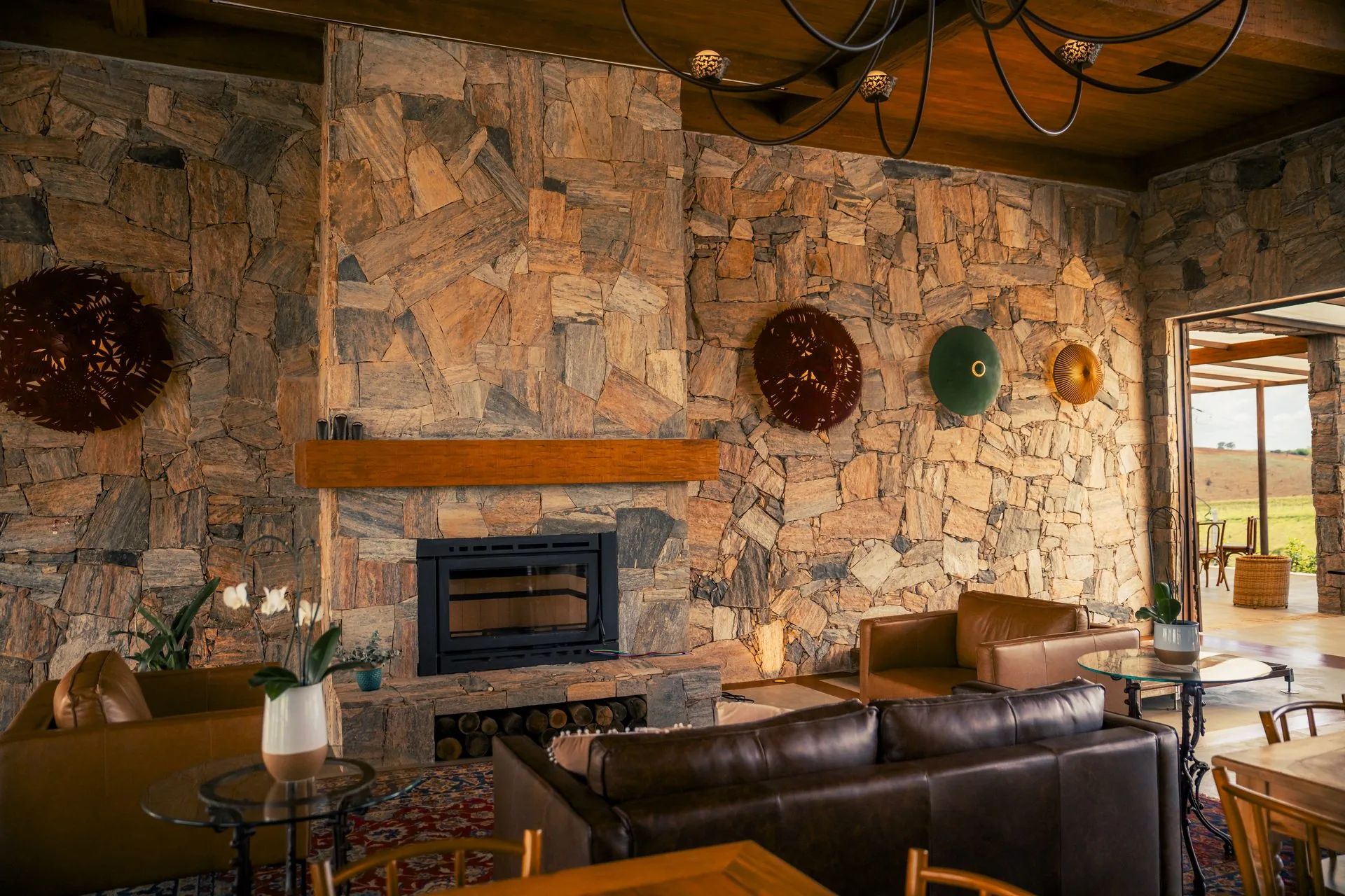 Lounge da Casa Vinnus com lareira e poltronas de couro